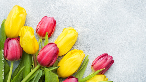 Bouquet of yellow and pink tulips on a light blue background. Copy space
