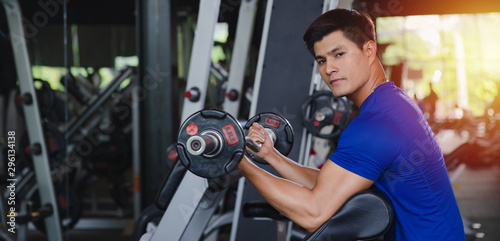 Healthy Asian man workout in gym training sport with dumbbell with sportswear