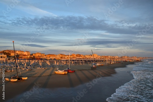 Photos Scenic view of the beach of Lido di Camaiore at sunset with the cityscape in the