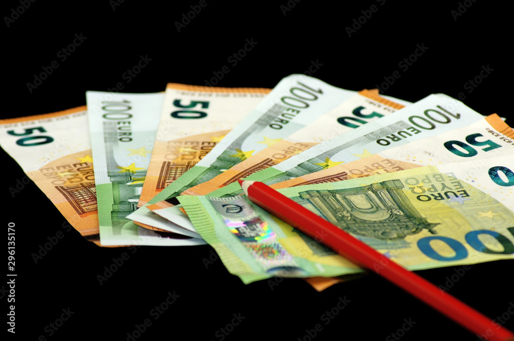 Rotstift auf Euro Geldscheine auf schwarzem Hintergrund Rotstift auf Euro Geldscheine auf schwarzem Hintergrund