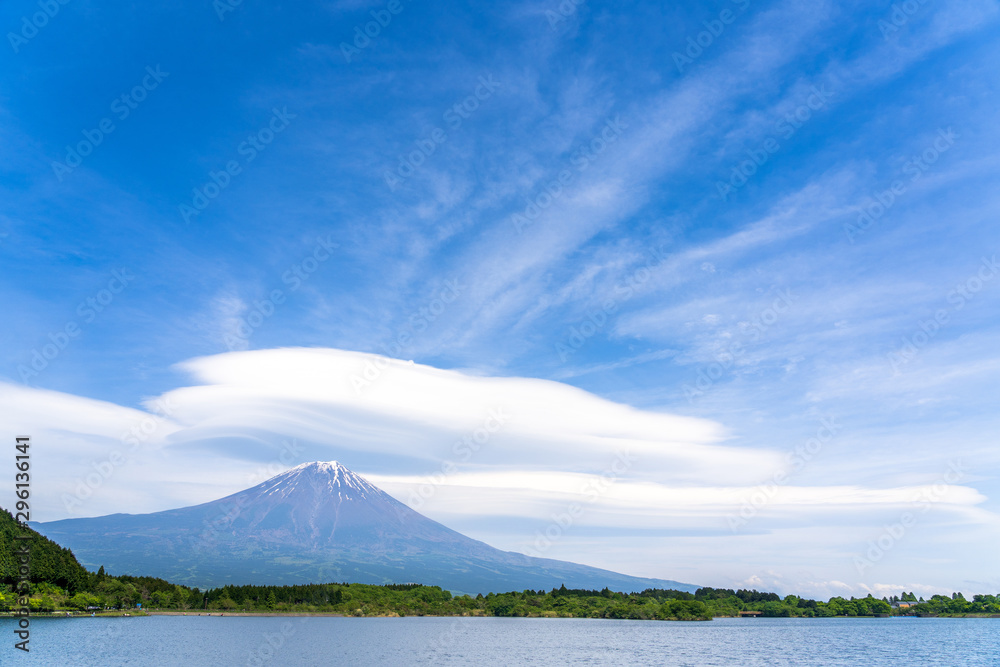 Fuji mountain with cloudy hat on top , fantastic clouds blue sky background spot view at Lake Tanuki (Tanuki-ko) in morning time near small hill and green forest foreground, Fujinomiya Shizuoka Japan.