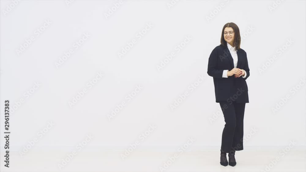 Full length attractive smiling businesswoman in suit standing, her hands folded, smiling joyfully, posing. Full length attractive smiling businesswoman in suit standing, her hands folded, smiling joyfully, posing.