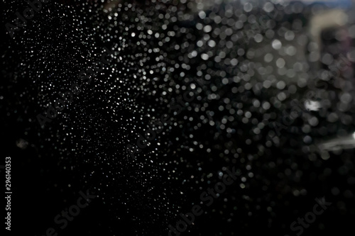 Abstract background of waterdrop bokehs on car window at night