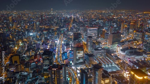 Aerial night hyper lapse over Osaka city with Umeda(Osaka) train station and many skyscraper building and vehicles. photo