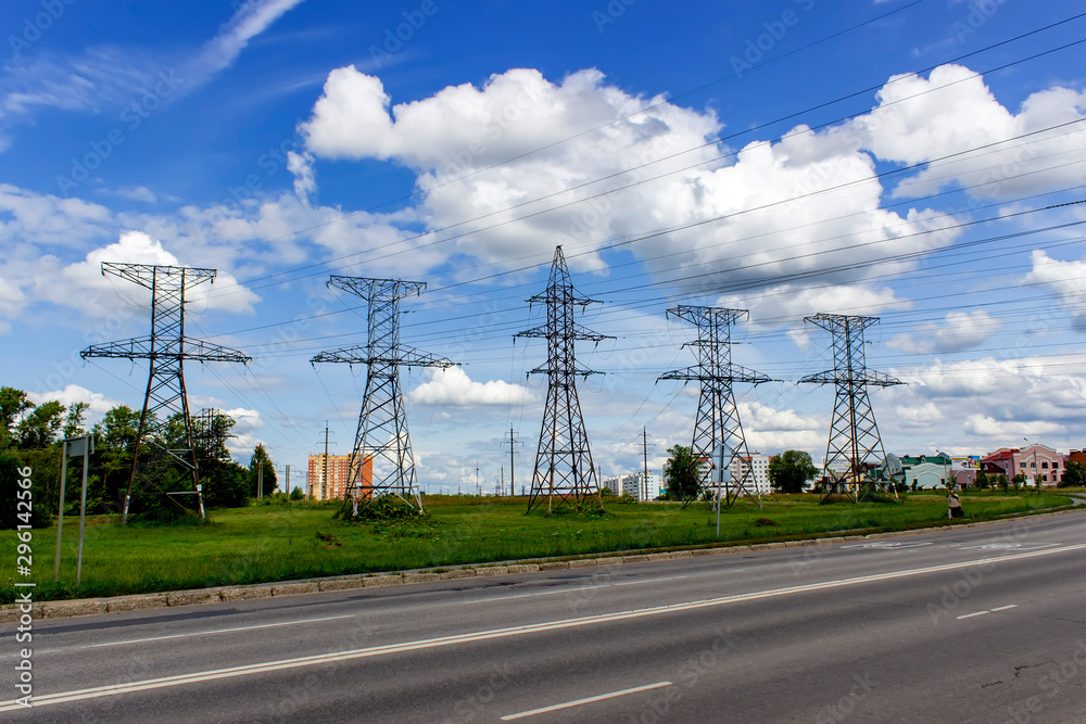 High voltage posts in scenic colourful summer landscape, industrial background.