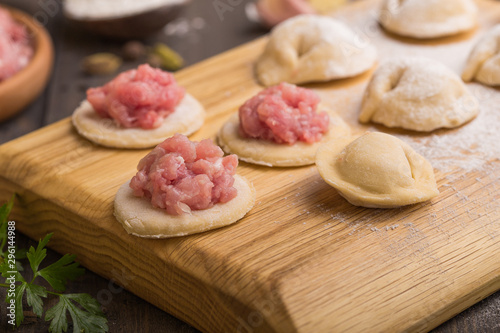 process of making home-made dumplings. Raw homemade dumplings on a wooden board. russian dumplings