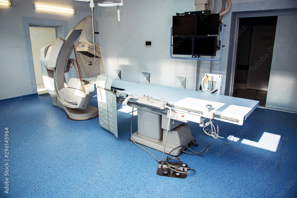 Angiographer in a modern hospital for heart surgery with a remote and monitors