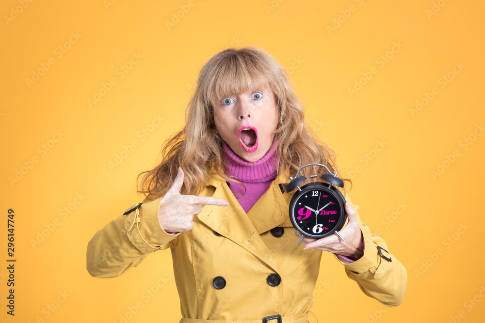 Fototapeta premium adult woman with alarm clock or alarm isolated on color background