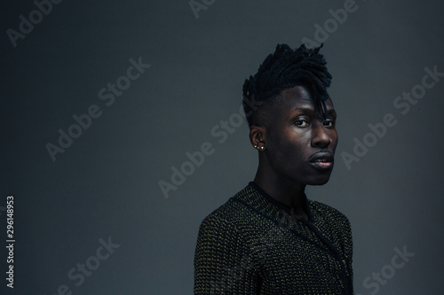 Portrait of a young man looking at camera on dark black studio background