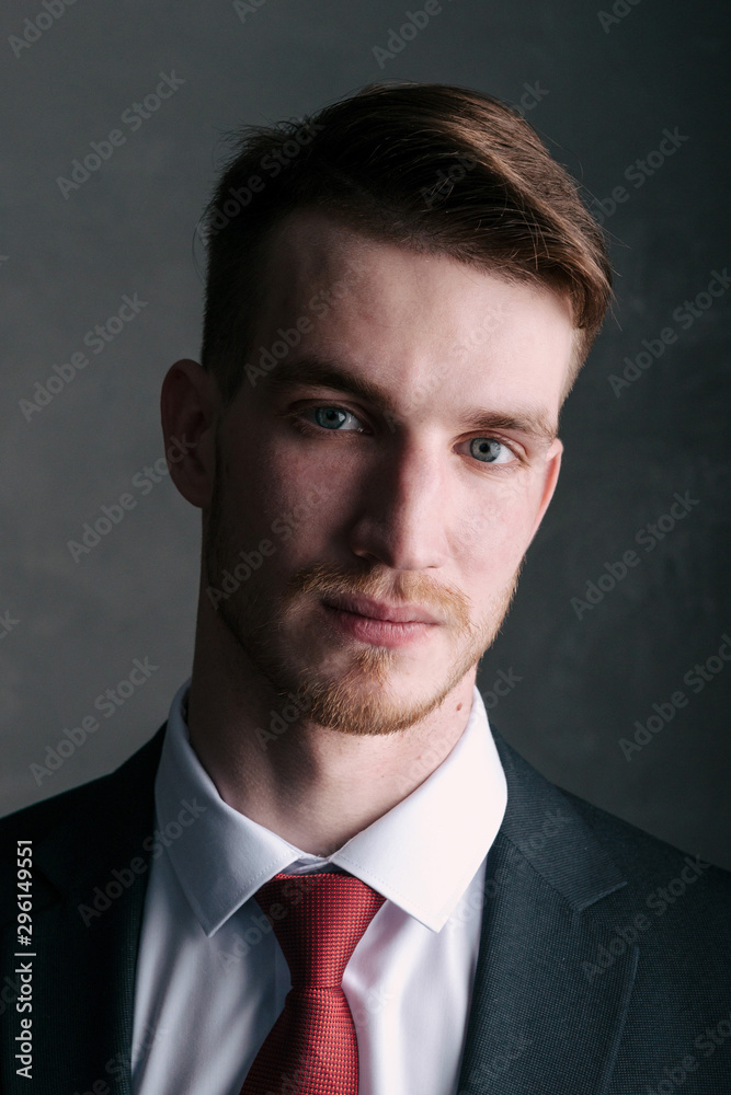 Young man in a black suit on a dark background Young man in a black suit on a dark background