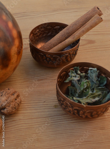 copper vessels with cinnamon sticks and nettle