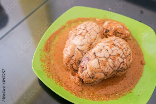 Whole cow brain with padang sauce dish cuisine on a plate is delicious food from indonesia