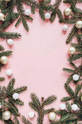 Christmas   New Year holiday composition. Mock up frame with blank copy space  fir needle branches  Christmas baubles on pink background. Flat lay  top view festive concept.