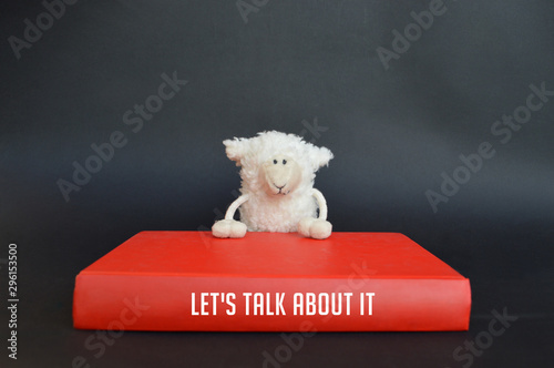 a funny sheep with book titled Let's talk about it, on a black background