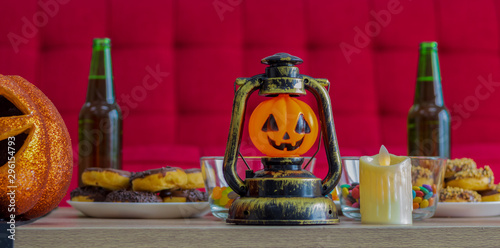 Orange Pumpkin On Halloween Night With Candles And Candies Drink in celebration of Halloween.