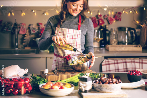 Young Woman Cooking in the kitchen. Healthy Food for Christmas (stuffed duck or Goose)