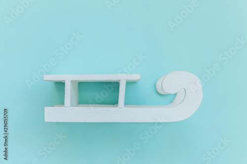 Simply minimal design composition white sled isolated on blue pastel colorful trendy background. Christmas New Year december time for celebration concept. Flat lay top view copy space photo