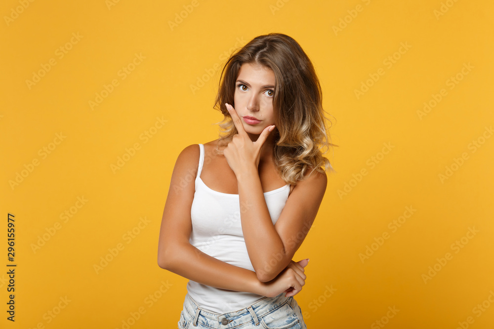 Young woman posing over yellow background. Emotional female