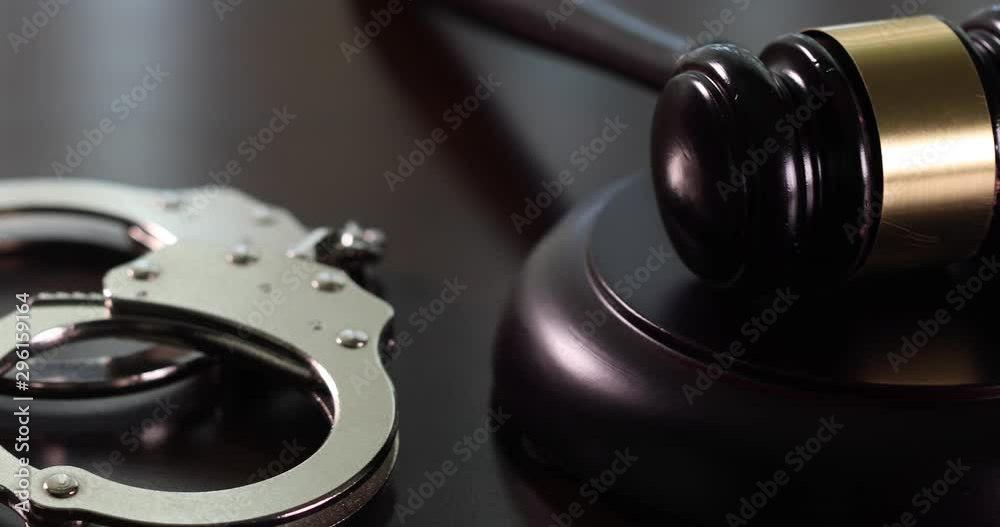 Slow Panning of Gavel and Handcuffs on Dark Wood Surface. Slow Panning of Gavel and Handcuffs on Dark Wood Surface.