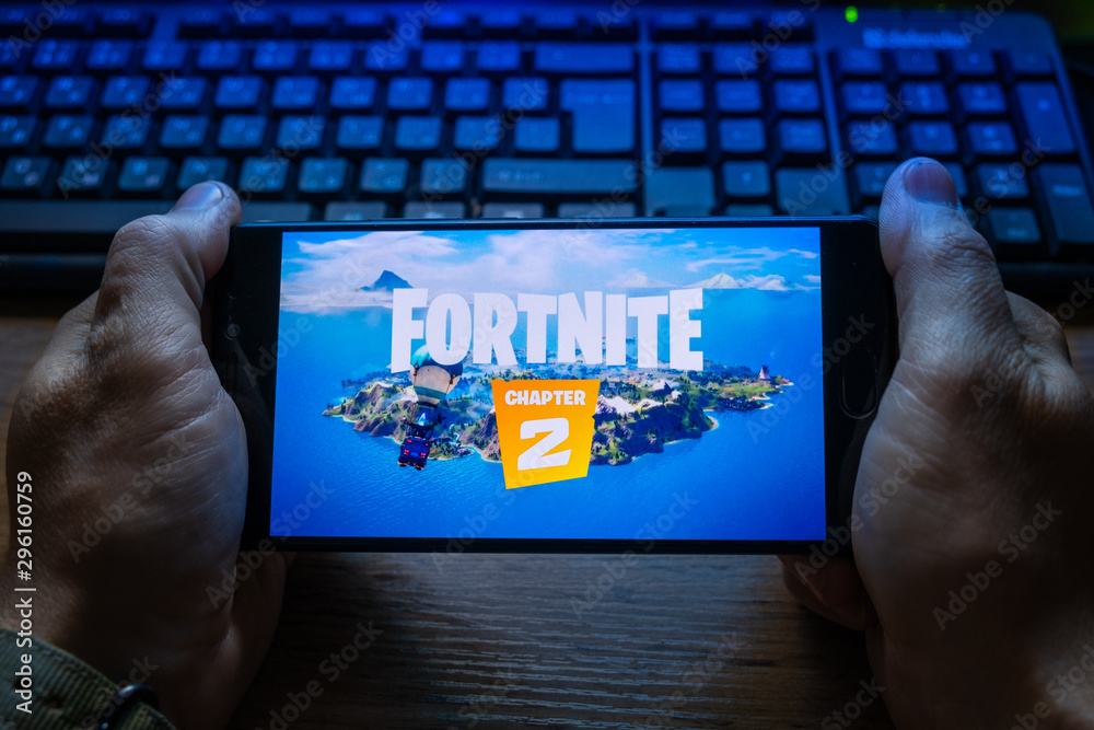 Kostanay, Kazakhstan, October 15, 2019.A man holds a mobile phone with a  screensaver of the popular game Fortnite 2, from Epic Games. Stock Photo |  Adobe Stock