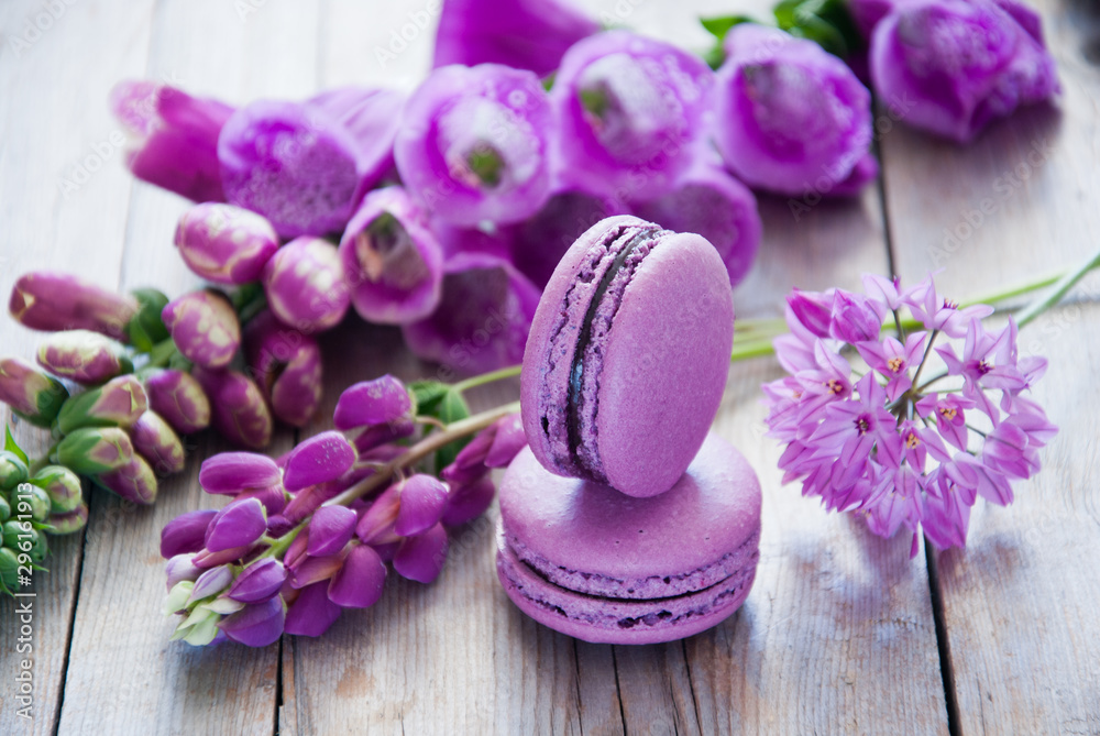 Purple flowers and macaroon on a wooden background Purple flowers and macaroon on a wooden background