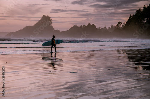 Tofino Vancouver Island, sunset at cox bay with surfers by the ocean during fall season Canada photo
