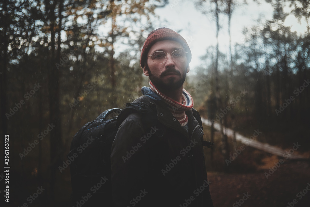 Portrait of young bearded hipster with backpack in the autumn forest. Portrait of young bearded hipster with backpack in the autumn forest.