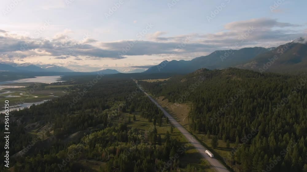 Aerial Panoramic View of a Scenic Highway in the Valley surrounded by Canadian Mountain Landscape. Taken in Kootenay, British Columbia, Canada. Aerial Panoramic View of a Scenic Highway in the Valley surrounded by Canadian Mountain Landscape. Taken in Kootenay, British Columbia, Canada.