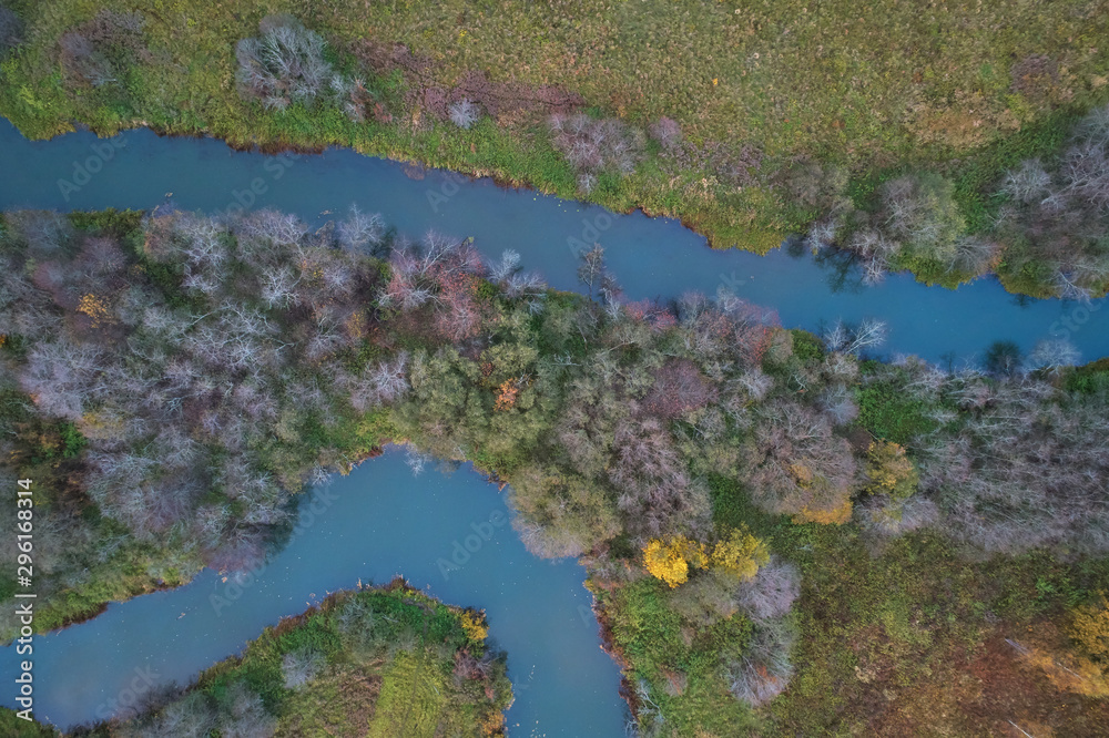 Aerial view with a drone. Winding river with autumn forest, top view Aerial view with a drone. Winding river with autumn forest, top view