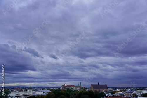 roofs of houses and a Church at sunset, the dark sky with clouds before a thunderstorm. old town top view. the observation deck on the roof