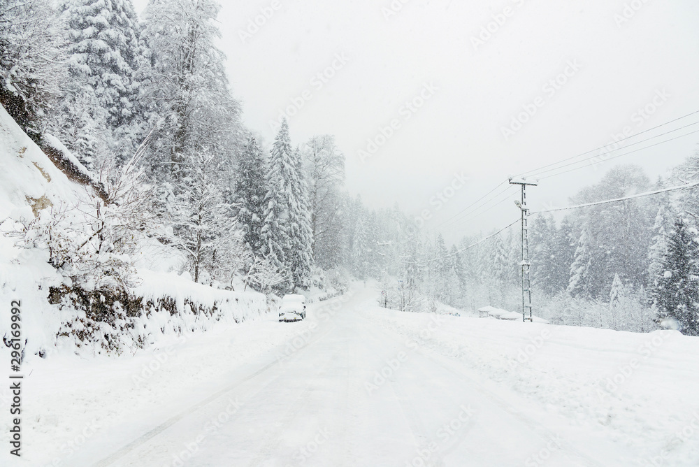 Snowy road in winter with an SUV parked. Snowy road in winter with an SUV parked.