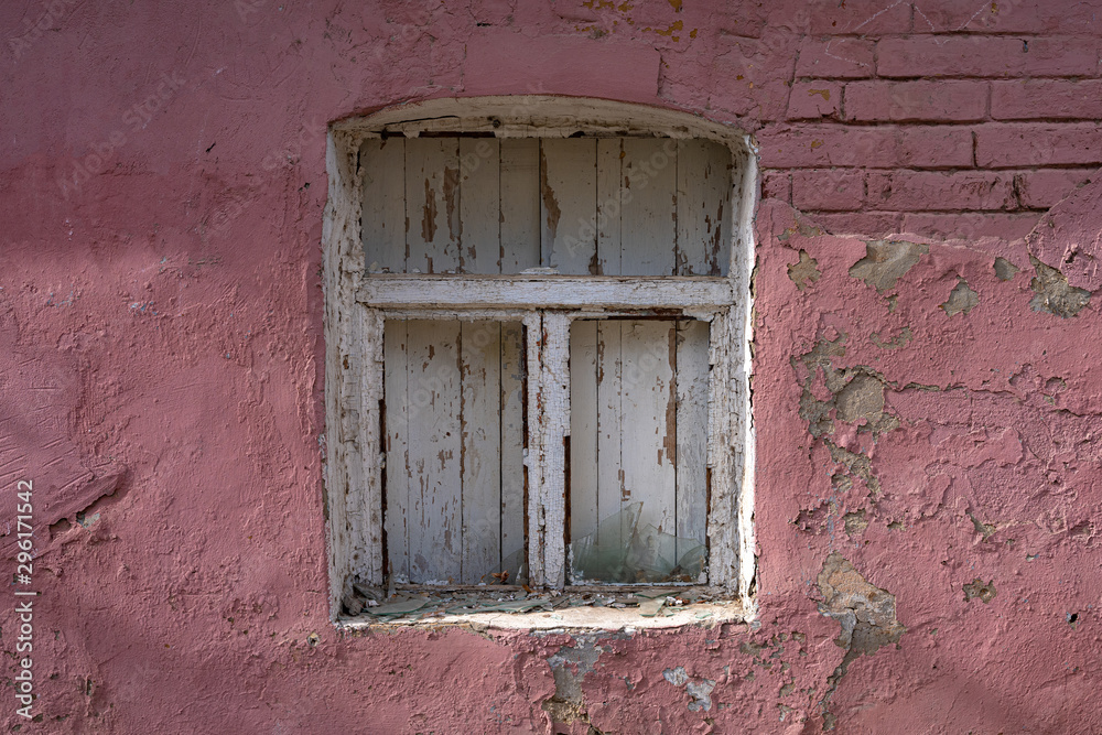 Closed window with a wooden frame in an abandoned brick house. Melancholy and loneliness concept