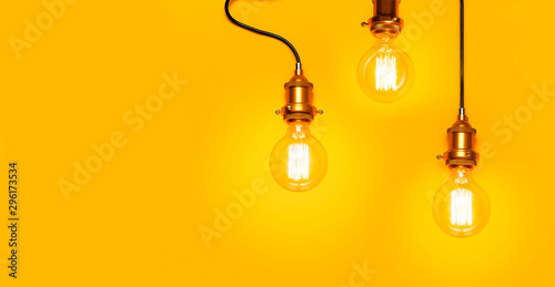Vintage fashionable edison lamp on bright yellow background. Top view flat lay copy space. Creative idea concept, designer lamp, modern interior item. Lighting, electricity, background with lamp
