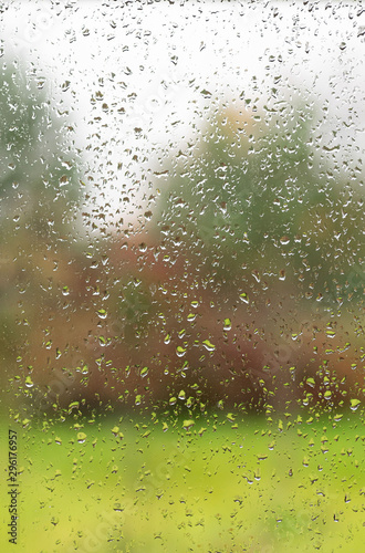 Raindrops on a window pane. The view from the room. Autumn weather concept.