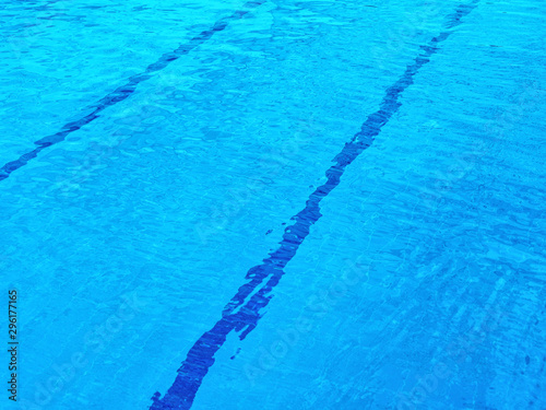 Pool with clear blue water. At the bottom of the pool, parallel lines are visible that cross the background diagonally
