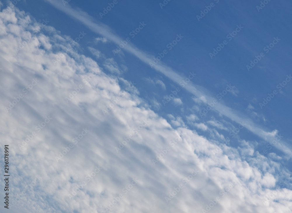 Summer background with white flying clouds on blue sky. Romantic natural heaven backdrop.