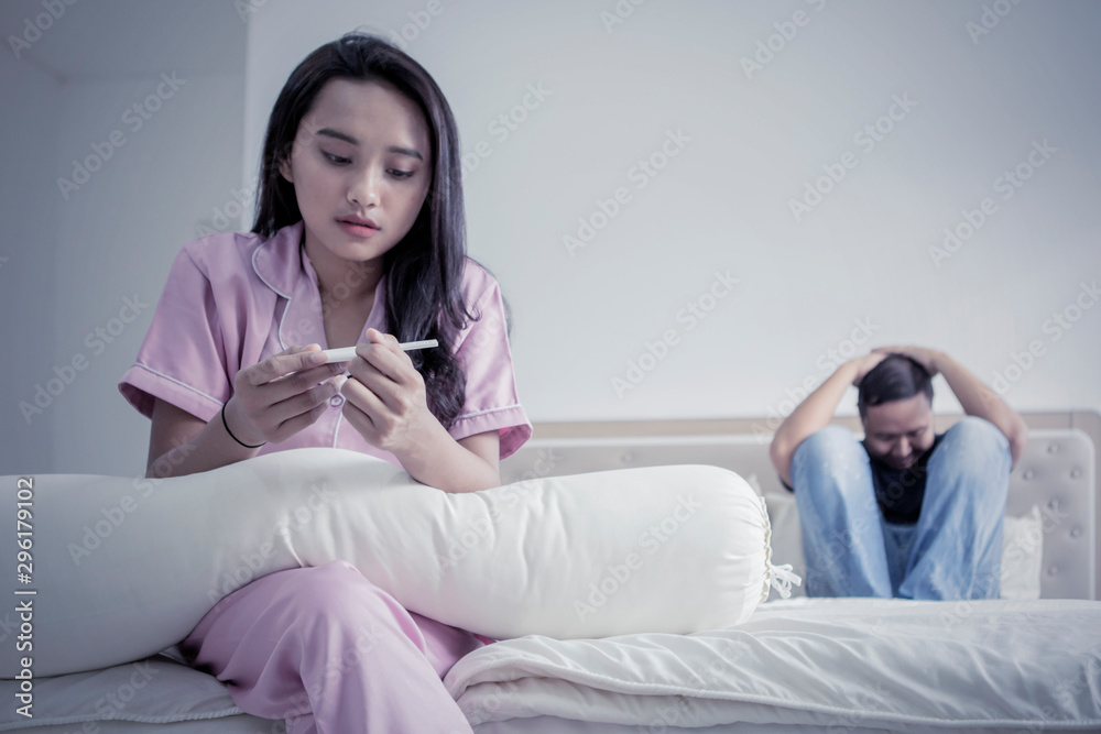 Depressed girl and boyfriend with pregnancy test Depressed girl and boyfriend with pregnancy test