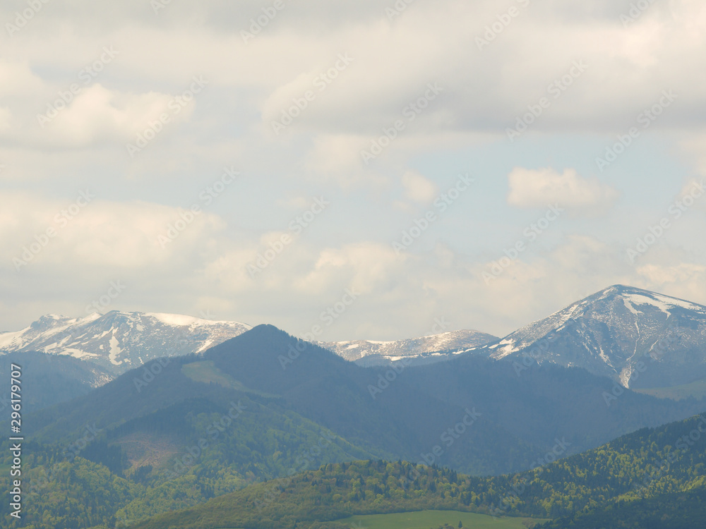 Morning landscape with mountains and blue sky. Evening sunset on the horizon of hills with white snow and cloud