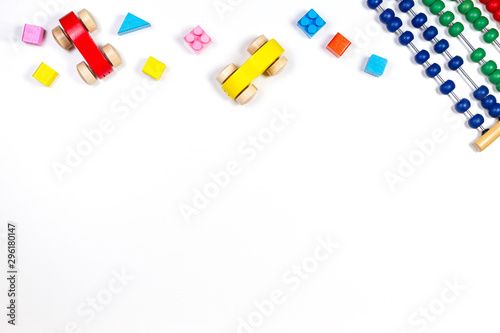 Baby kids toys frame with toy abacus, wooden cars and bricks on white background. Top view, flat lay. Copy space for text