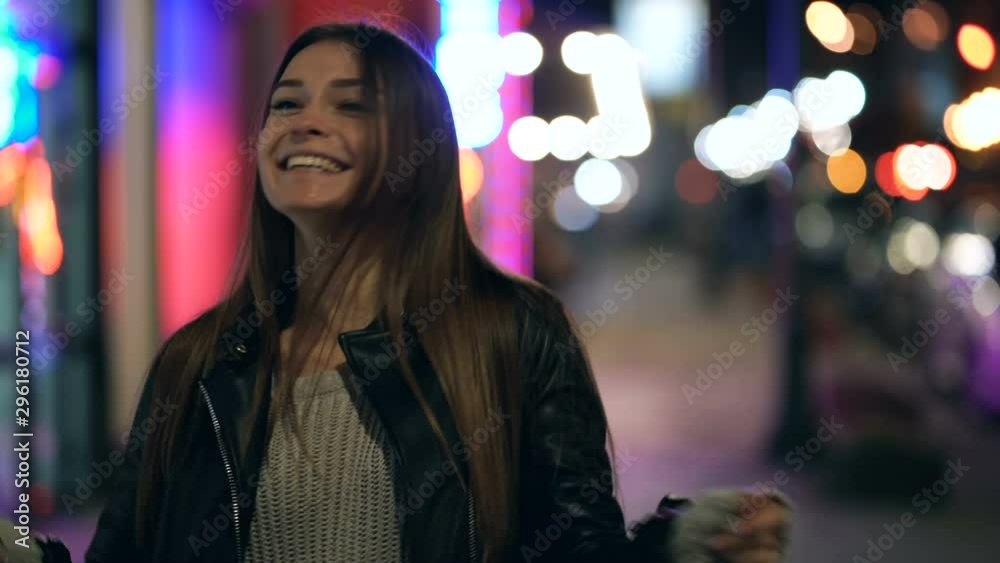 Happy, smiling and laughing young woman standing at the street and having fun. Evening time. Happy, smiling and laughing young woman standing at the street and having fun. Evening time.