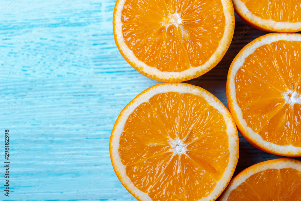Sliced orange fruit on blue wooden blackground, pop art color concept. Top view. Blank space. Sliced orange fruit on blue wooden blackground, pop art color concept. Top view. Blank space.