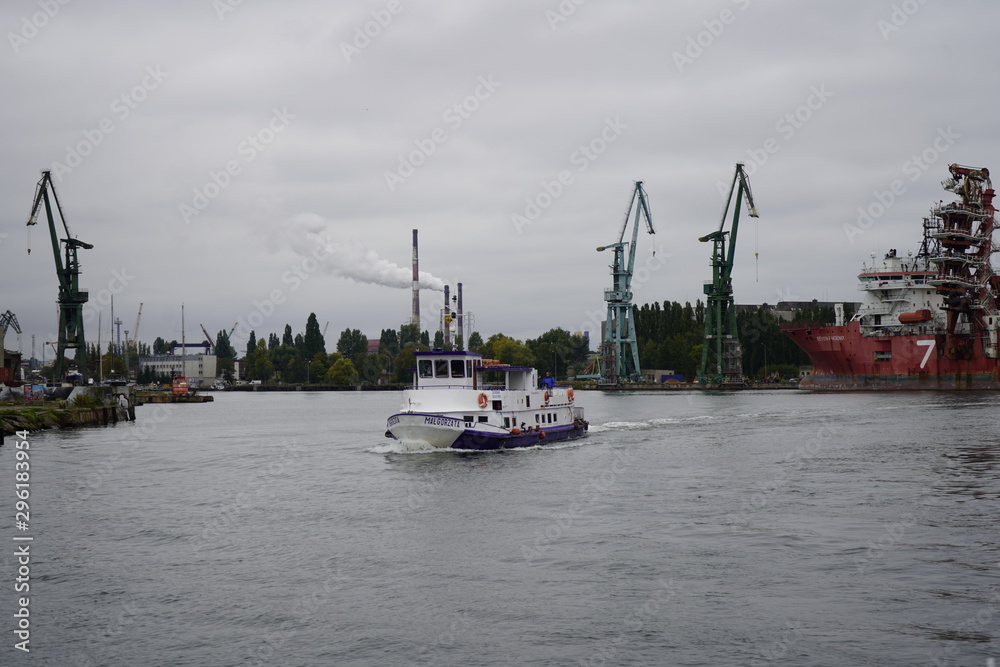 Gdansk, Poland - September 2019: View of the Gdansk Shipyard, shipyard. Gantry crane and moored ship. The tanker is moored in the port.