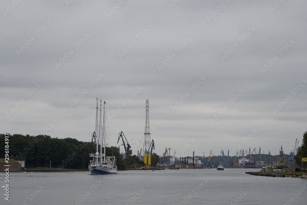 Gdansk, Poland - September 2019: View of the Gdansk Shipyard, shipyard. Gantry crane and moored ship. The tanker is moored in the port.