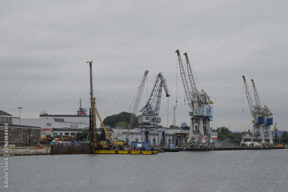 Gdansk, Poland - September 2019: View of the Gdansk Shipyard, shipyard. Gantry crane and moored ship. The tanker is moored in the port.