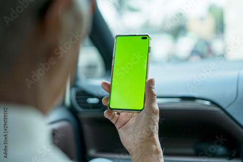 Unknown old man using a phone with in car