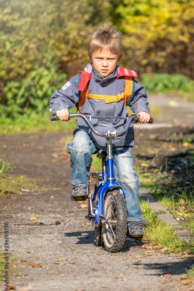 Little boy rides a bicycle in the autumn park. Little boy rides a bicycle in the autumn park.