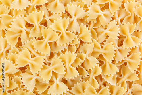 Variety of types and shapes of Italian pasta. Dry pasta background. A portion of Farfalle bows pasta isolated on white . Heap of bow tie pasta isolated on white background. photo