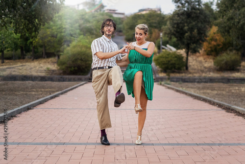 Swing dancers having fun outdoors in the park. Lifestyle concept about people dancing swing music Lindy hop together and having fun!
