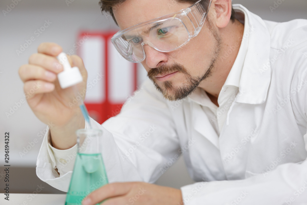 a scientist looking at test-tube a scientist looking at test-tube