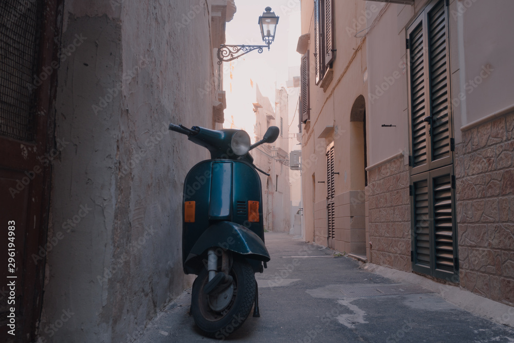Scoter is parked in a iconic alley of a south italy town during a summertime